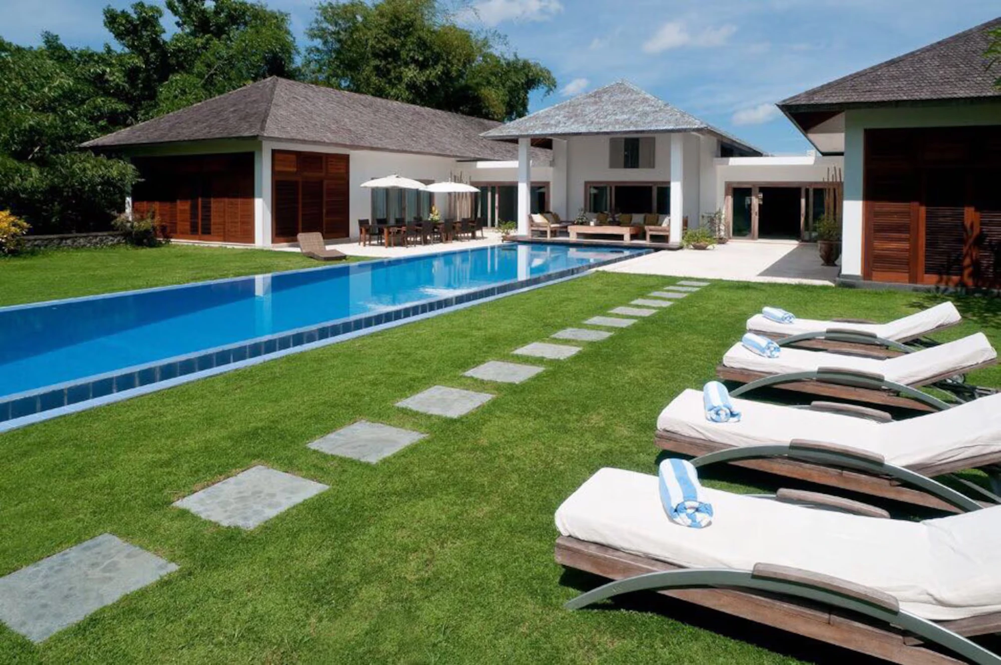 The villa in Ubud: a long pool, a lawn and sun loungers