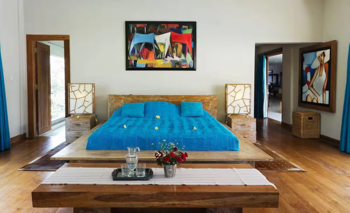 Bedroom with a low wooden bed and a blue cover